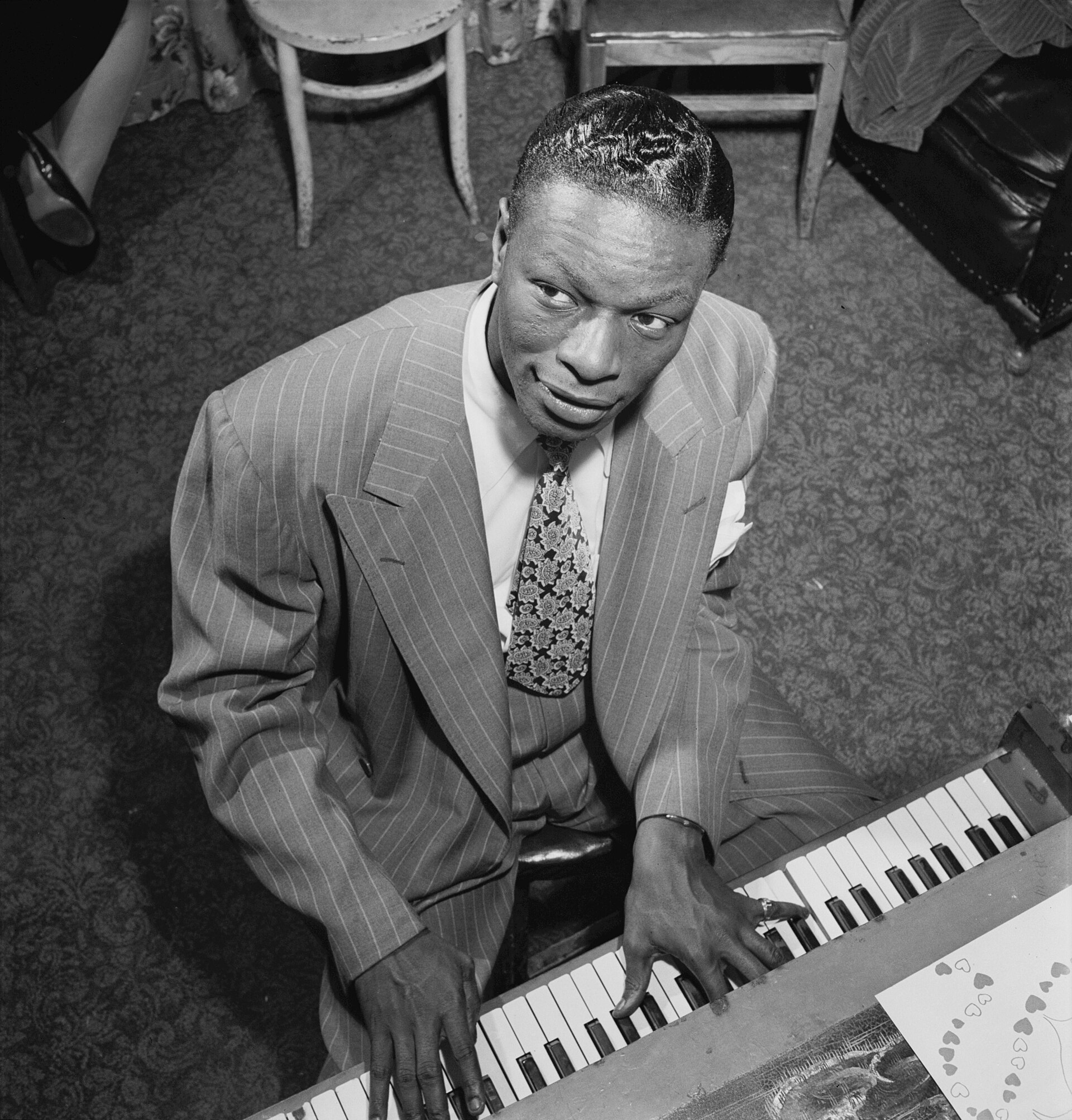 Imagem de referência relacionada a Nat King Cole, item descrito como cantor e pianista estadunidense