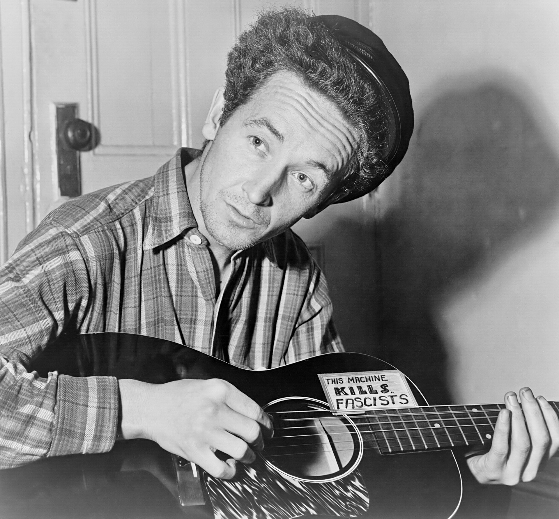 Imagem de referência relacionada a Woody Guthrie, item descrito como cantor e compositor americano de folk
